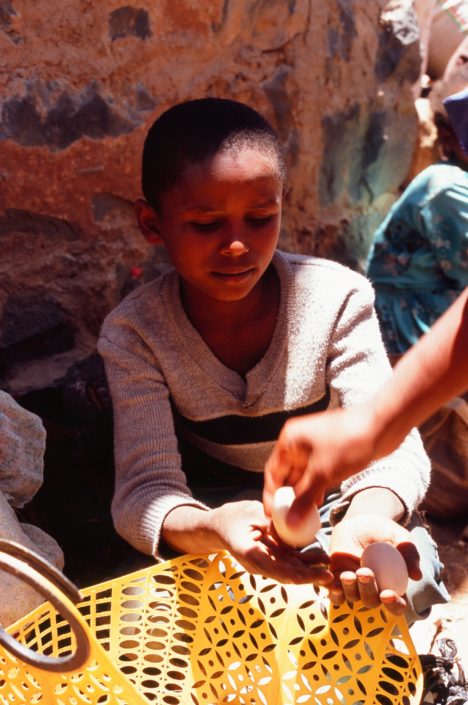 A young girl sells eggs in a market