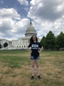 Robin standing in front of the US Capitol Building, wearing a Dan Koh for Congress t-shirt. She is smiling, and her hands are on her hips in a power pose. 