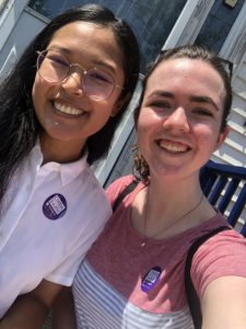 Cinda and Robin are smiling at the camera in a selfie, while sitting together on a porch. They both have purple stickers that say "Cinda Danh for Ward 6 City Council."