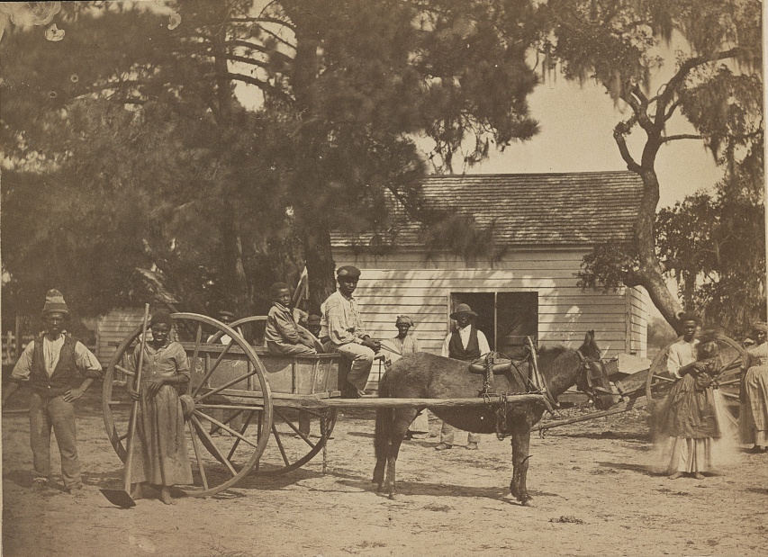 people on a horse-drawn cart in front of a building